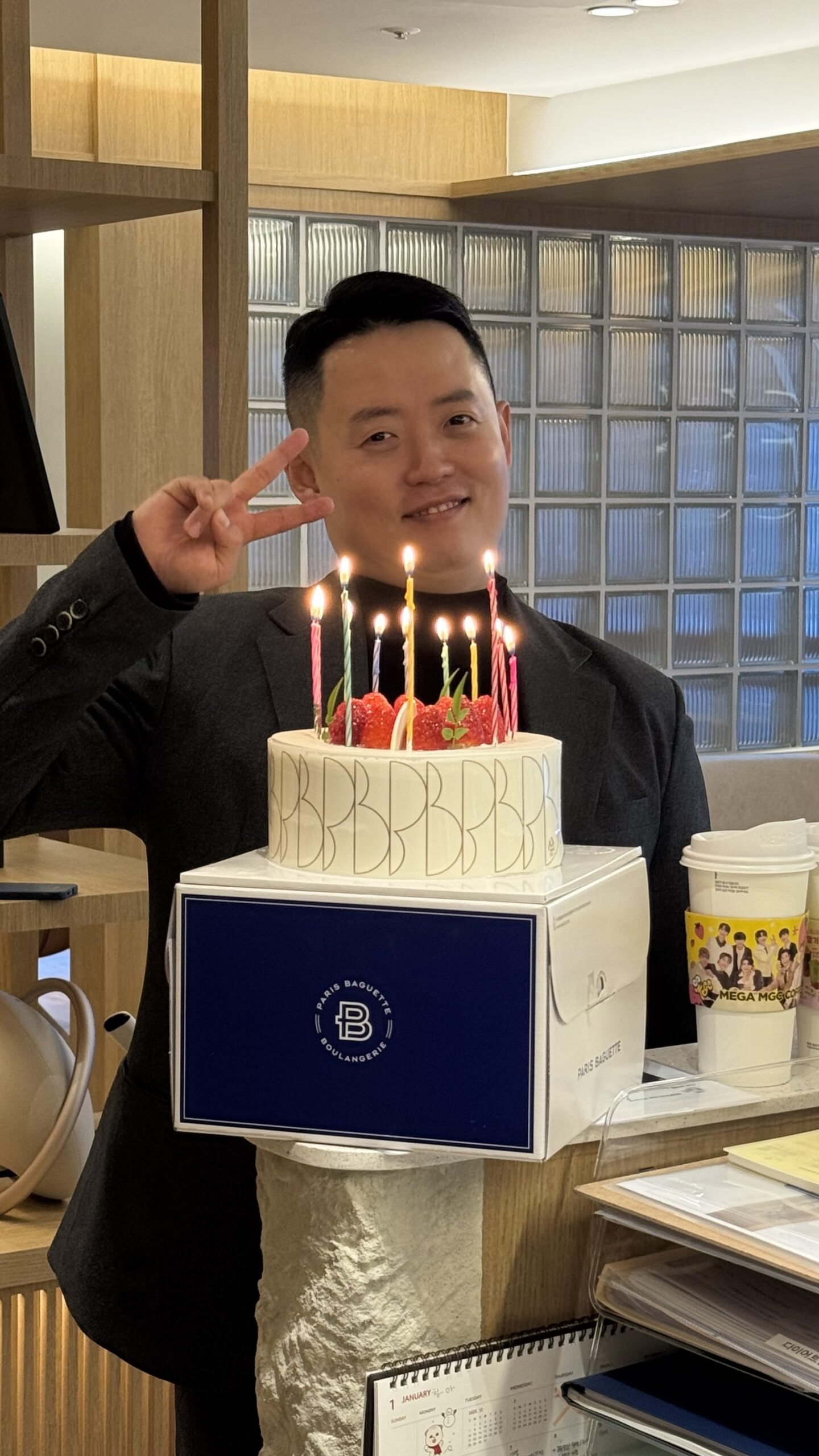 촛불을 켠 케이크를 들고 브이 포즈를 한 사진
